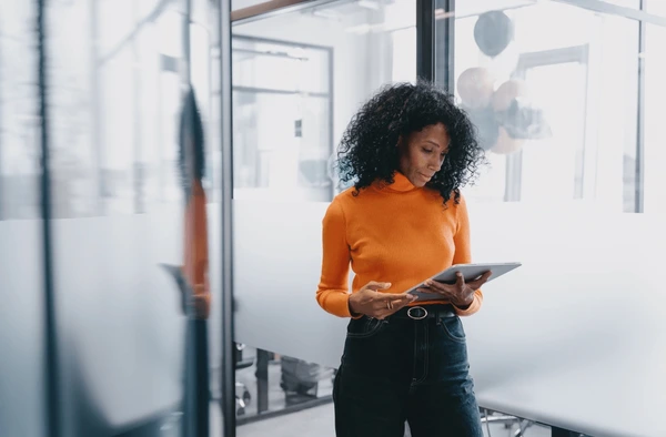 Professional African businesswoman using tablet in modern office